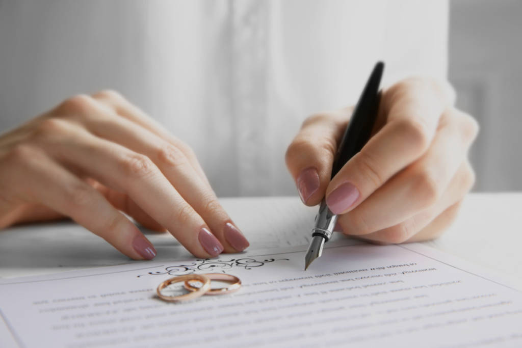 Mujer firmando un matrimonio por poderes