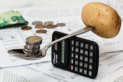 calculadora haciendo de balanza con dinero y patata