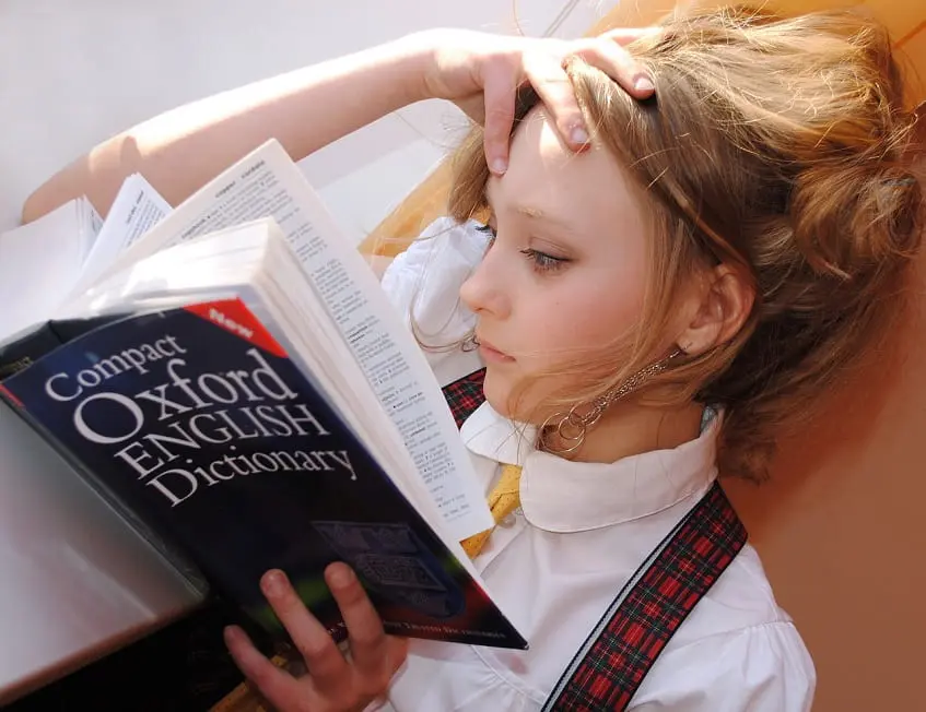 adolescente leyendo diccionario de inglés