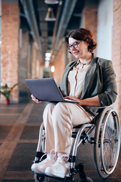 mujer en silla de ruedas sujetando portátil
